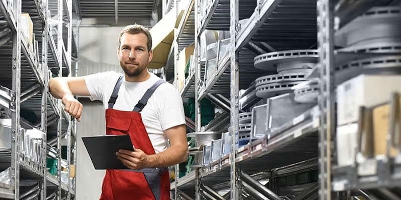Parts clerk standing in between shelves of parts